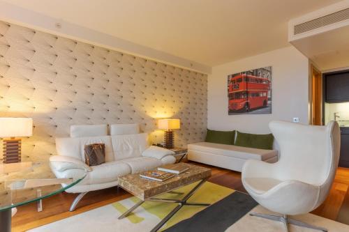 a living room with a white couch and a red bus at Pestana Chelsea Bridge Hotel & SPA in London