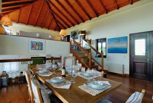 a dining room with a wooden table with wine glasses at Yialenia Estate in Rikia