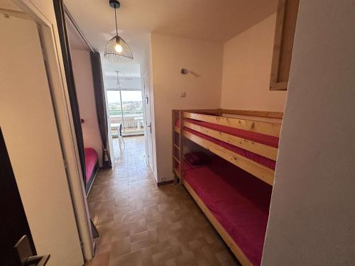 un couloir avec une chambre avec un banc et une fenêtre dans l'établissement Studio 2 cabines 4 pers avec parking, vue mer - Port Camargue - FR-1-731-130, au Grau-du-Roi