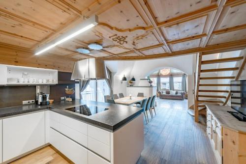 a large kitchen with white cabinets and a dining room at Sport- und Genusshotel Silvretta in Ischgl