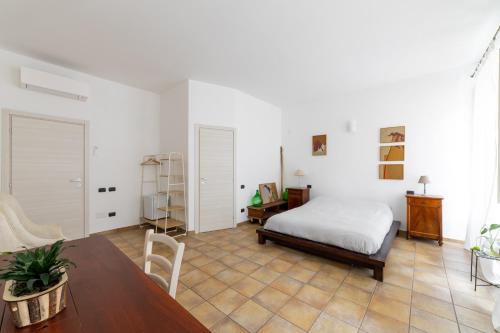 Un dormitorio con una cama, un escritorio y una mesa. en Casa Marina Guesthouse Cagliari, en Cagliari