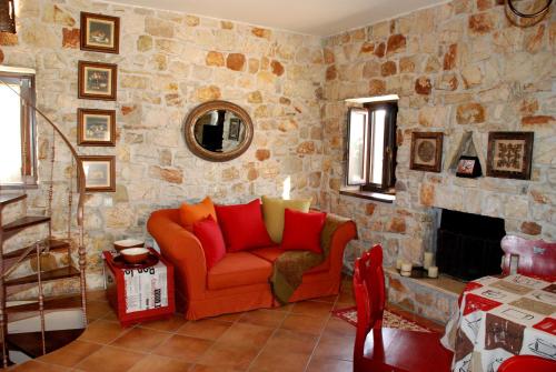 a living room with an orange couch and a stone wall at Yialenia Estate in Rikia