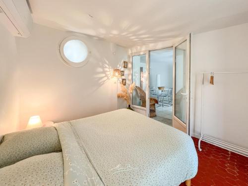ein weißes Schlafzimmer mit einem Bett und einem Fenster in der Unterkunft La Marinièro à 350m des plages - 4 couchages - Wifi in Toulon