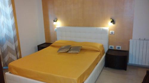 a bedroom with a bed with a yellow blanket on it at Antico Centro Quartu in Quartu SantʼElena