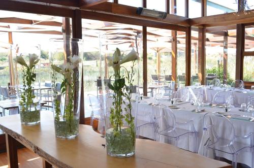 a table with white flowers in glass vases on it at Forum Homini Boutique Hotel in Krugersdorp