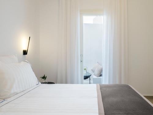 a bedroom with a large white bed with a window at Sunset Windmills House in Mýkonos City