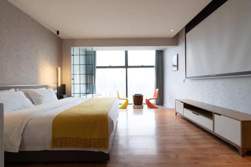 a bedroom with a large bed and a large window at 重庆宿江云端高空江景酒店 in Chongqing
