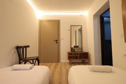 a room with two beds and a chair and a table at N'konak Guesthouse in Pukë