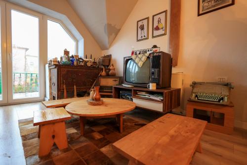 een woonkamer met een tv en een tafel bij N'konak Guesthouse in Pukë
