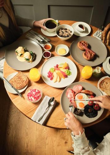 a table with plates of breakfast food on it at The Queensberry Hotel in Bath