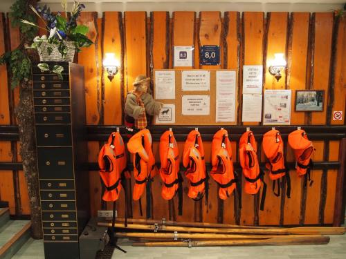 a woman standing in front of a rack of orange gloves at Nelijärve Holiday Centre in Aegviidu