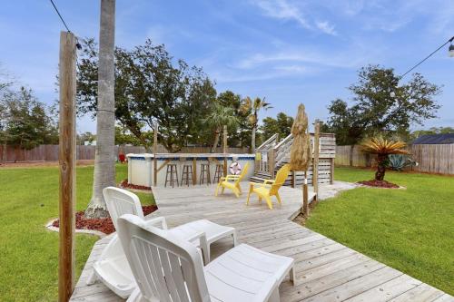 a wooden deck with chairs and a playground at Poolside Palms Paradise in Navarre