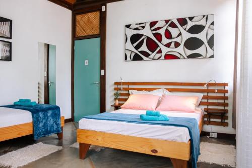 a bedroom with two beds with blue and pink at Atelier Arte Paraty Mirim in Paraty