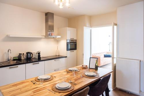 a kitchen with a wooden table with plates on it at Historic Canal House Apartment in Amsterdam