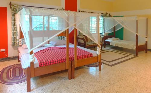 1 dormitorio con 2 camas y 1 cama con dosel en Gold golf, en Ukunda Airport