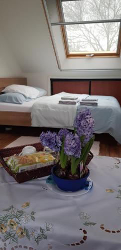a table with purple flowers in a room with a bed at Volendam in Volendam