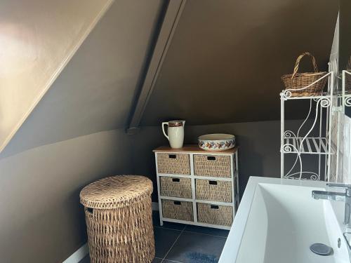 La salle de bains est pourvue d'un lavabo blanc et d'un tabouret. dans l'établissement Couleur Café, à Honfleur