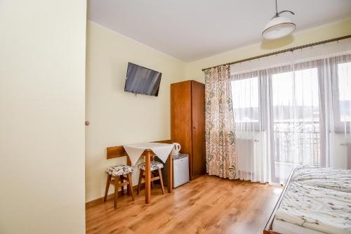 a room with a bed and a table and a window at U Pawlikowskich in Poronin