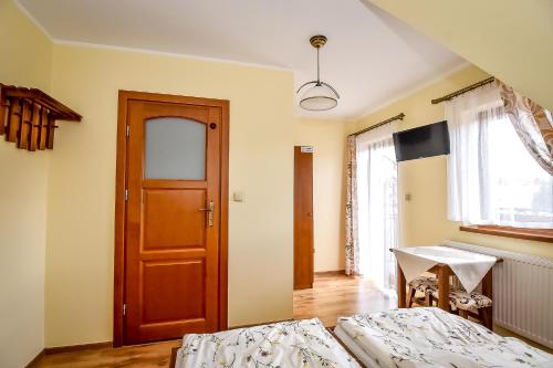 a bedroom with two beds and a wooden door at U Pawlikowskich in Poronin