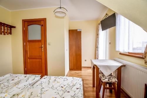 a bedroom with a bed and a desk and a table at U Pawlikowskich in Poronin