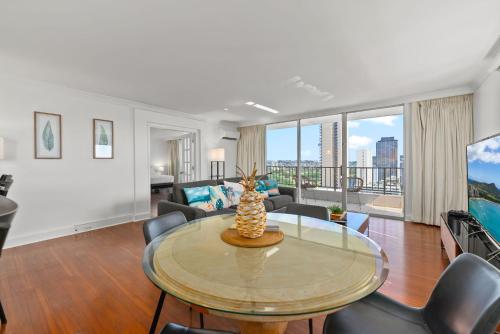 a living room with a table and chairs at Honu Hale Penthouse 2 BDR Ocean View Waikiki in Honolulu