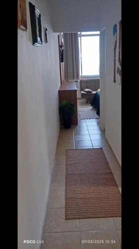 a hallway with a tile floor and a room with a window at Apto com Vista para o Mar in Santos