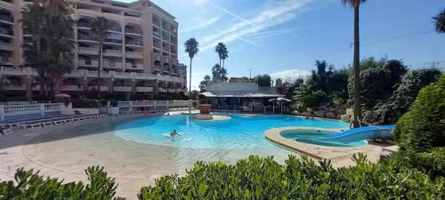 une grande piscine devant un immeuble dans l'établissement Cosy Blue Classé 2 étoiles Piscine Parking Clim Terrasse, à Cannes