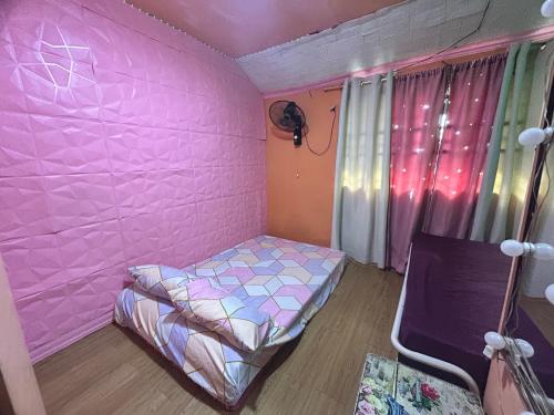a pink bedroom with a bed and a window at 1 AC BR House 400mbps, Netflix,Parking,Massager,Cook in Rodriguez