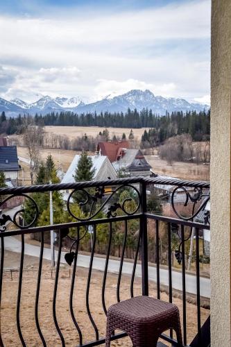 a balcony with a chair and mountains in the background at U Pawlikowskich in Poronin