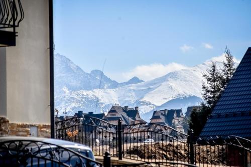 a view of a town with snow covered mountains at U Pawlikowskich in Poronin