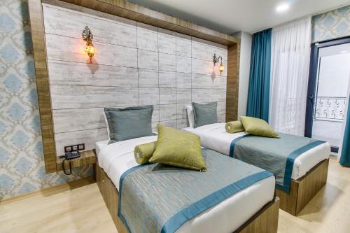 a bedroom with two beds and a wall at Elite World Nest Sivas in Sivas