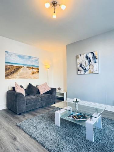 a living room with a couch and a glass table at Marine Apartment Whitley Bay Seaside Location Free Onsite Parking in Whitley Bay