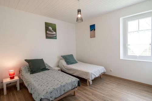 une chambre avec deux lits et une fenêtre dans l'établissement Maison Amélia, à Parentis-en-Born