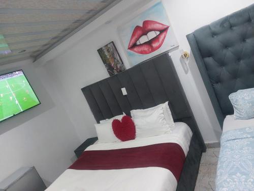 a bedroom with a bed and a tv with a kiss on the wall at Gold Crown International Hotel With Complementary Breakfast and WiFi in Johannesburg