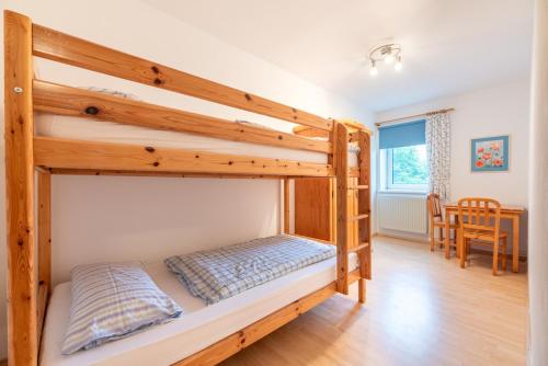 a bunk bed in a room with a table at Ferienhof Bruhn "Nr 2" in Midlum