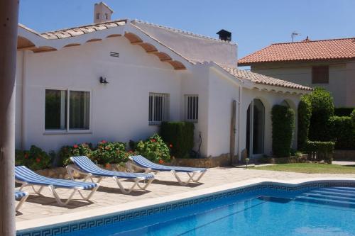 a house with two chairs and a swimming pool at Villa Mediterránea in Calafat