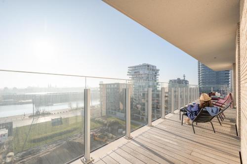 a person sitting in a chair on a balcony with a view at Sixt Haven, panoramisch appartement Oosteroever, Oostende in Ostend