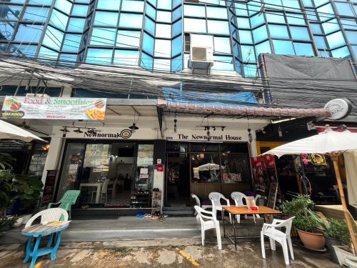 a restaurant with chairs and tables in front of a building at The New Normal House in Chiang Mai