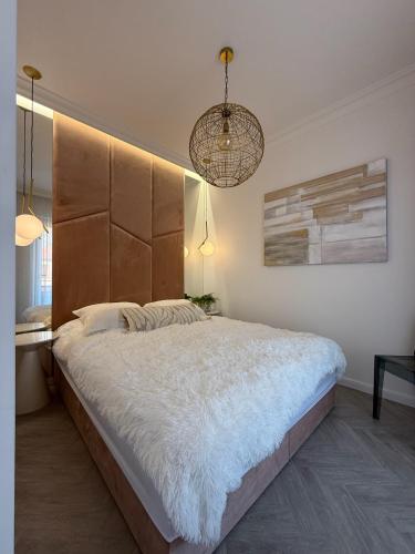 a bedroom with a large bed with a large headboard at Apartament Pod Żaglami 1 in Sława