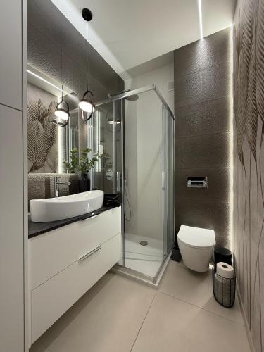 a bathroom with a toilet and a sink and a shower at Apartament Pod Żaglami 1 in Sława