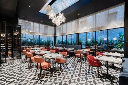 a restaurant with tables and chairs and large windows at The Goethe Hotel - Small Luxury Hotels of the World in Rome