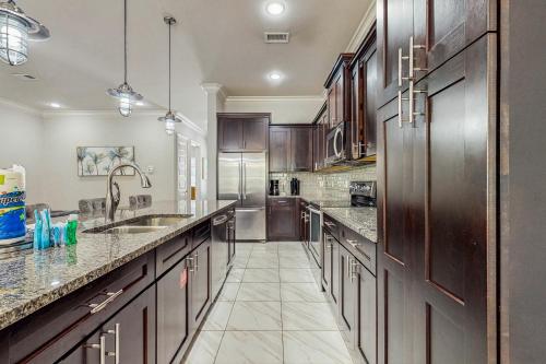 a large kitchen with wooden cabinets and marble counter tops at Miramar Beach Villas #946B in Destin