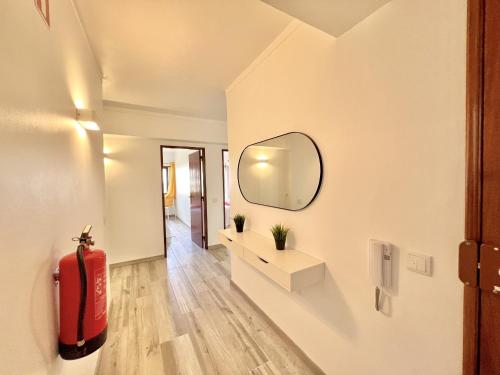 a living room with a mirror and a red fire extinguisher at Quarteira Brightness by Homing in Quarteira