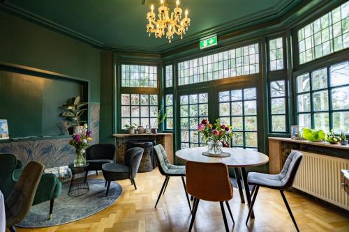 a room with a table and chairs and windows at B&B Willem II in Roermond
