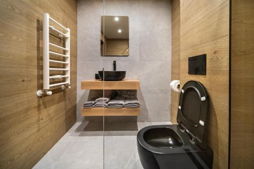 a bathroom with a black toilet and a sink at Калоянова крепост in Arbanasi