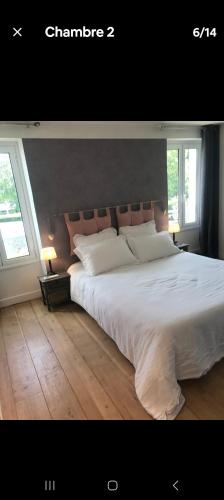 - une chambre avec un grand lit blanc et 2 fenêtres dans l'établissement Ravissante maison de ville, à Saint-Cloud