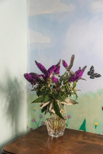 a glass vase filled with purple flowers on a table at Panoramic villa with pool in Bolsena
