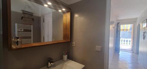 une salle de bain avec un lavabo et un miroir dans l'établissement Frejus Plage a 50m des plages, 1er etage de villa, à Fréjus
