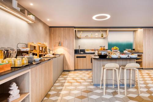 a kitchen with a counter and stools in a restaurant at Citadines Les Halles Paris in Paris