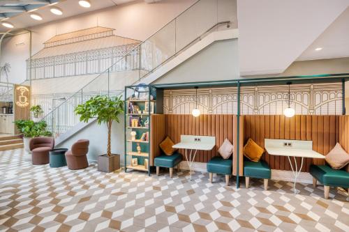 un hall avec des tables et des chaises ainsi qu'un escalier dans l'établissement Citadines Les Halles Paris, à Paris